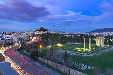 希腊雅典Lycabettus山夜间与鲁因斯和奥林匹亚宙寺柱希腊雅典Lycabettus山的全景图片