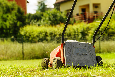 园艺服务旧割草机在后院砍伐绿草场阳光明媚的日间用割草机修剪场用坪修剪用割机修剪坪图片