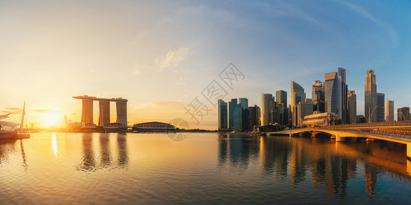 MarinaBay地区新加坡下城市的全景和反射日落时金融区和摩天大楼背景图片