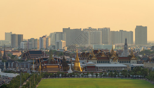 翡翠佛寺大宫殿WatPhoSanamLuangWatPhraKaew和摩天大楼日落时曼谷市中心泰国佛教寺庙图片