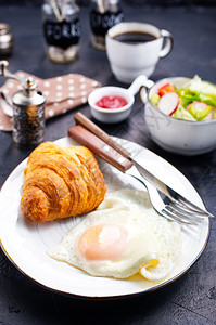 餐桌上的早炒鸡蛋和羊角面包图片