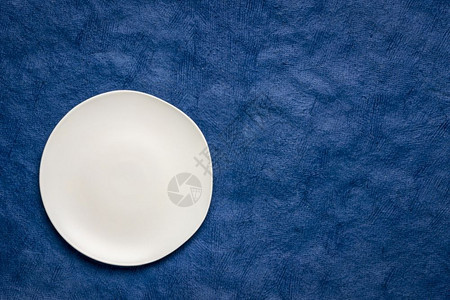 白色陶瓷板黑蓝手工制HuunMayan纸上不规则边缘有复制空间的白色陶瓷板图片