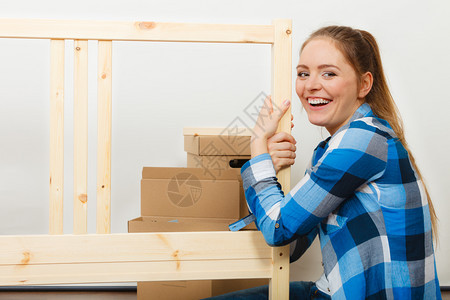 女人组装木制家具DIY爱好者做家庭改良的年轻女孩DIY图片