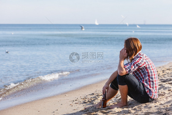 男人在海滩上喝酒图片