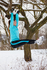 冬季运动户外健身时尚康概念女孩在树上锻炼图片