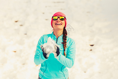 年轻女持雪冬季公园放松乐趣健康自然时装身概念图片