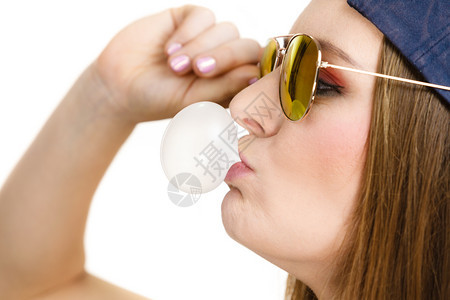 女随意时尚的少女帽戴头太阳眼镜用嚼口香糖来泡用嚼口香糖来泡图片
