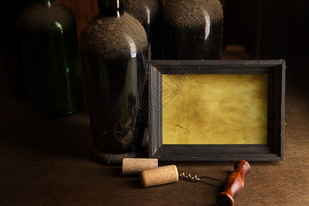 与旧的粉尘葡萄酒瓶corkscorscrew和空白框自己文字的空间图片