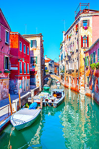 在意大利阳光明媚的日子里在威尼斯用停泊的机动船靠在意大利威尼斯的狭窄侧运河图片