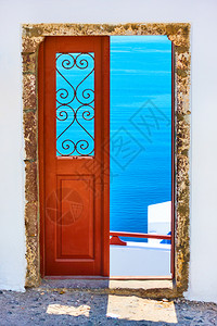 在希腊圣托里尼通过开放的门穿爱琴海图片