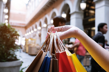 购买数亚洲女孩持有销售袋的购物中心消费主义生活方式概念背景