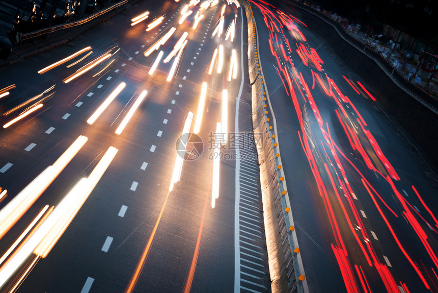 夜晚现代城市的车灯在高速公路上行驶图片