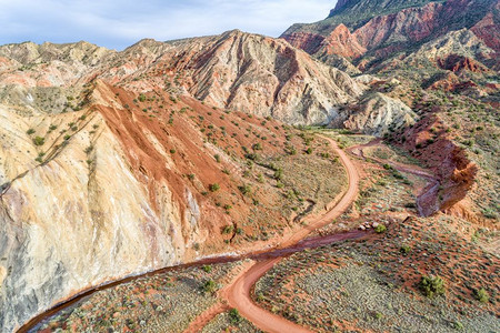 沿犹他州穆阿布地区的洋葱溪和土路一带多彩岩层和陡峭悬崖的空中景象图片