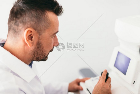 光学医生检查他的病人和观察一台机器专业医疗设备光学生检查病人和观察一台机器图片