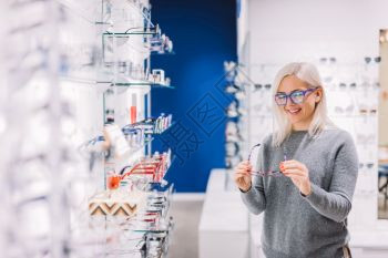 女人在光学商店看眼镜购物选择眼罩视力缺陷图片