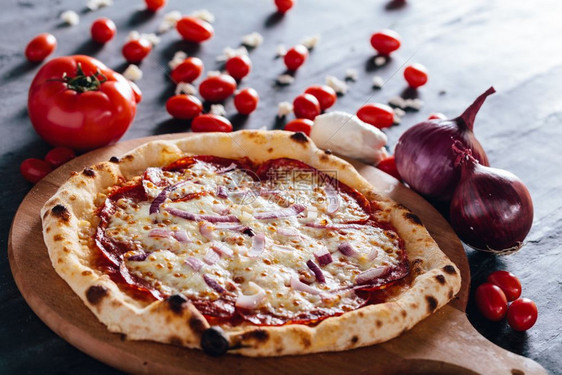 木板上带沙拉米莫扎雷和红洋葱的披萨莫扎雷拉和红洋葱的番茄背景中马扎雷拉和红洋葱流行传统食物莫扎雷拉和红洋葱的披萨图片