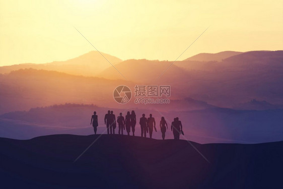 日落时站在山丘上的一群商业界人士图片
