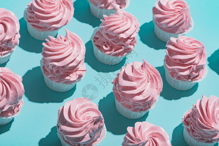 粉红纸杯蛋糕面粉蓝色背景的红纸杯蛋糕图片