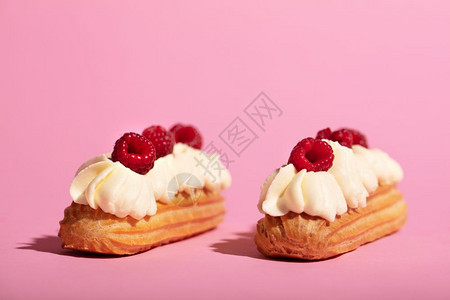 两个彩色的花朵放在粉红色背景上法国甜点自制糕图片