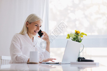 女人在电话上说用笔记本电脑在家工作自由在线图片