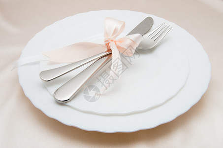 白色盘子叉和刀放在浅色背景上图片