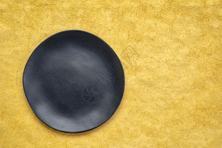 黄手工制作的HuunMayan纸上有不规则边缘的黑瓷板和复制空间的黑瓷板图片
