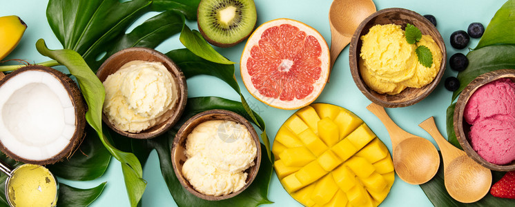热带水果和植物以蓝底平原的椰子壳中各种冰淇淋形式以椰子壳中各种冰淇淋形式植热带水果和物图片