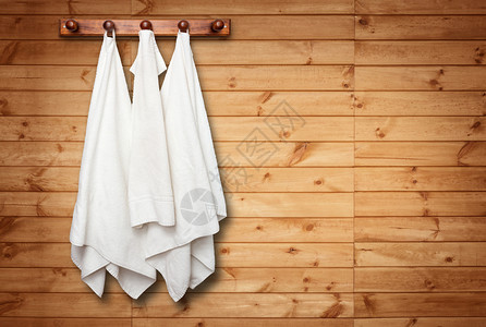 木墙上挂着干净毛巾的衣架图片