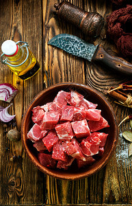切菜板上的生牛肉，烤成牛排图片