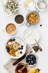 带酸奶蜂蜜新鲜香蕉蓝莓碗里香薯种子和白底咖啡的燕麦加奶酸碗里香菜和咖啡图片