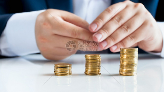 坐在办公桌后面的有三堆金币商人近照图片