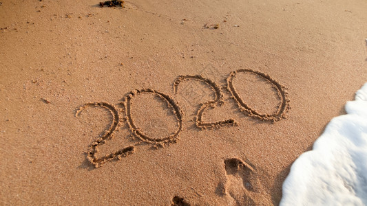 在海滨湿沙上写下20年数字的贴近照片在海边湿沙上写下20年数字的贴近照片图片