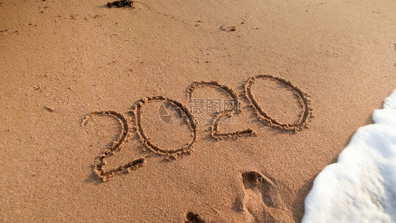 在海滨湿沙上写下20年数字的贴近照片在海边湿沙上写下20年数字的贴近照片图片