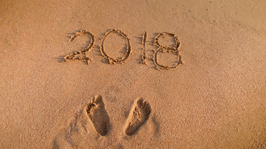 在沙滩上写下2018年数字的近距离图像冬季假日庆祝和旅行的概念2018年数字的近距离照片在沙滩上写冬季假日庆祝和旅行的概念图片