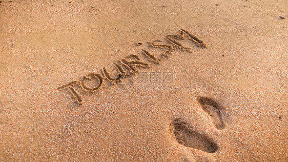 在湿沙滩上写下两条脚印和文字旅游的图片图片