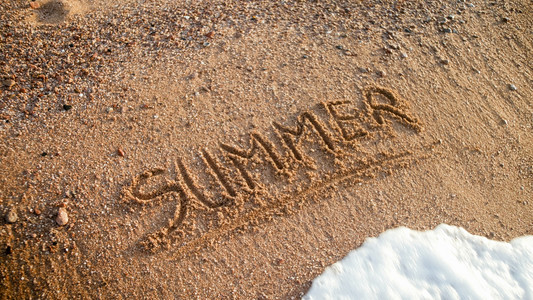 在湿沙滩上写下字的夏日特照片旅游行和的概念在湿沙滩上写下字的夏日特图片旅游行和的概念图片