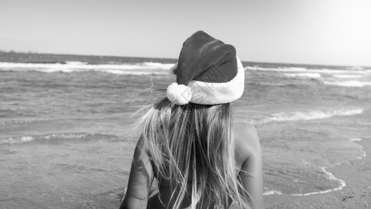 穿着Santa戴着Santa的年轻女黑白照片戴着Santa戴着帽子的年轻女黑白照片戴着圣诞新年和冬季假期的旅行和游概念穿着San图片