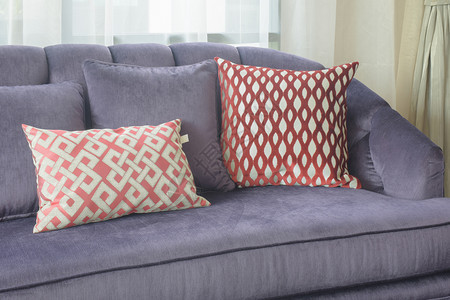 红式枕头放在客厅紫色沙发上图片