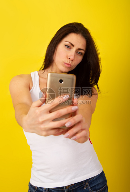 穿着时装便衣的迷人黑头发女孩在电话上拍自图片