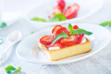 白盘上加草莓的蛋糕图片