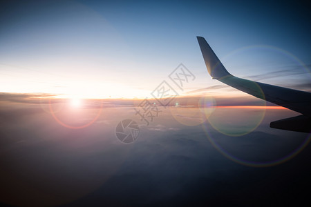 飞机拍摄旅客在飞机窗玻璃前拍摄日出背景