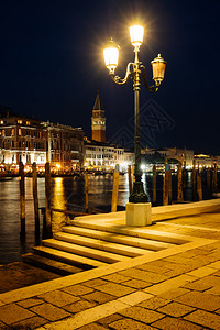 威尼斯运河和古老的建筑夜里歌多拉斯图片
