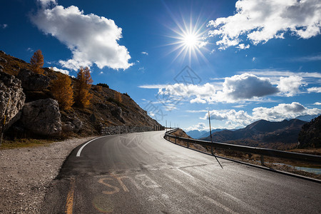 在意大利多洛米特山谷的公路上看到沥青草地山蓝天云和太阳高山公路欧洲旅行意大利多洛米特山谷公路柏油云和太阳图片