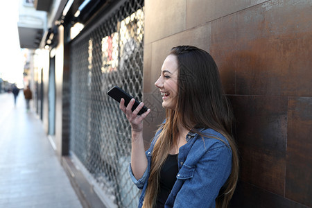 快乐女孩在智能手机上使用语音识别图片