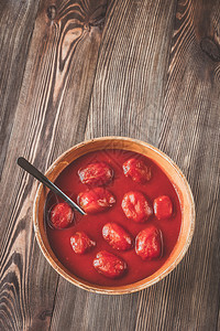 木背景上一碗番茄罐头图片