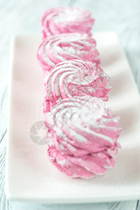 粉色蛋糕白色盘子上的棉花糖背景