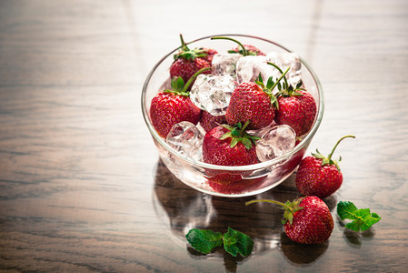 玻璃碗里有冰块的新鲜草莓图片
