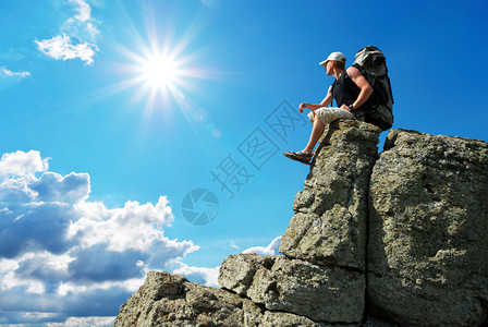 人坐在山顶上岩石图片