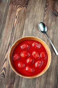木背景上一碗番茄罐头图片