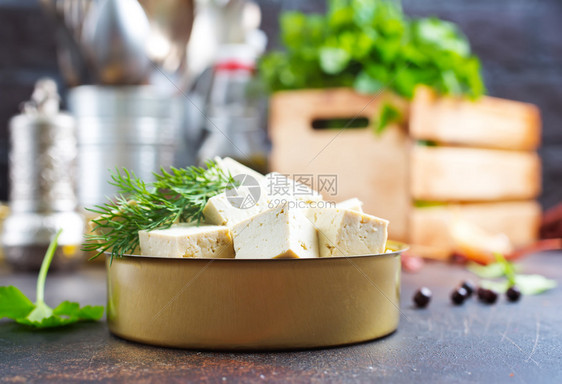 饭桌上金属碗中的豆腐干酪图片